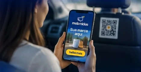 Passageira no banco de trás usando o celular, com o QR Code da MobMídias no encosto à frente